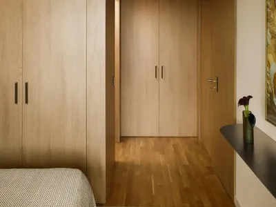 A cozy bedroom with wooden floors and door, featuring a bed, dresser, and painting on the wall, with a warm and natural ambiance