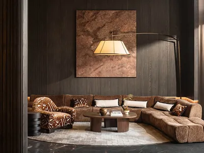A dimly lit living room with a brown couch and chair, wooden floor, and brown and white color scheme, creating a cozy atmosphere for conversation and relaxation