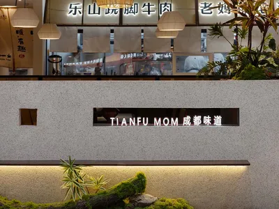 一間充滿光芒和歡迎感的餐廳，擁有大型窗戶、花盆植物、餐桌以及現代簡約空間的裝飾元素