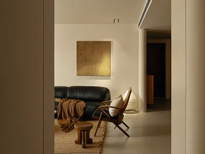 A well-lit living room with a brown couch, a wooden chair, and a rug, creating a cozy and inviting atmosphere