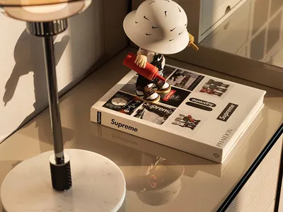 Cozy living space with a white table, a book, and a figurine, surrounded by a couch and a chair