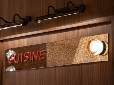 一個燈光充足的餐廳，木質招牌上寫著"Cuisine",創造了一個溫暖舒適的氛圍