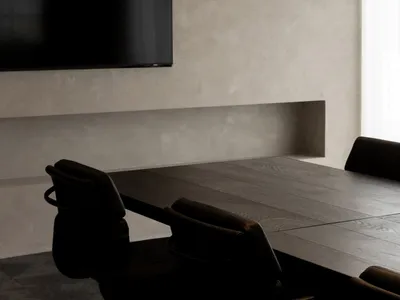 A black and white photograph of a cozy living room with a wooden table and two chairs, a flat screen TV on the wall, and a timeless classic atmosphere