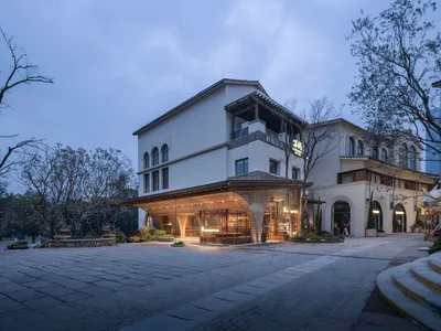 一座現代酒店建築，具有玻璃的前面，混凝土的外觀，歡迎入住的入口，充滿自然光線的照明
