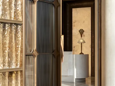 Bathroom with a brown and white color scheme, featuring a sink, mirror, and light fixture, with natural light coming in through the windows