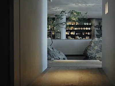 A cozy store with a rock wall and a tree in the corner, featuring bowls of various sizes on the wall
