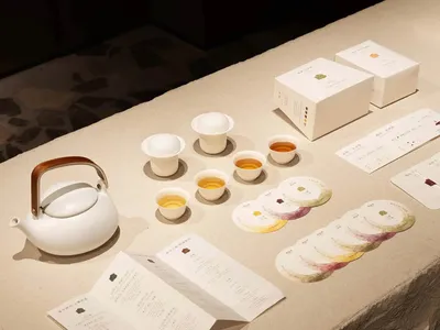 A wooden table in a restaurant setting with a teapot, cups, and bowls arranged in a visually appealing manner, inviting a pleasant dining experience