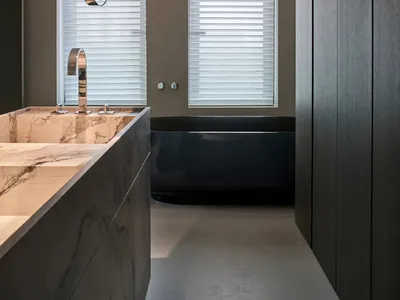 Bathroom with a marble countertop, sink, shower, and bathtub in a dimly lit space