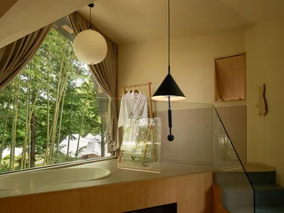 Bathroom with a wood fireplace, sink, and towel rack in a dimly lit space with a wooden floor