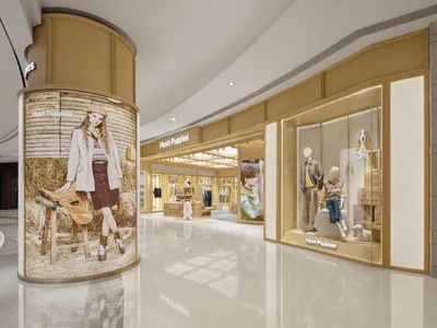 A modern clothing store with mannequins showcasing outfits, natural light, and a clean design