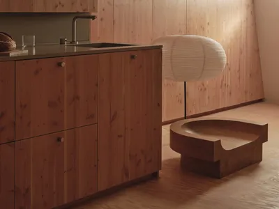 Well-lit kitchen with wooden cabinets, a sink, and a bowl on the countertop, creating a warm and cozy atmosphere