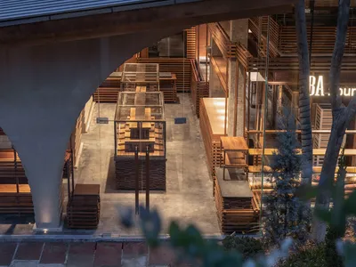 Warm and inviting living and dining area with wooden floors and walls, a dining table, and dim lighting