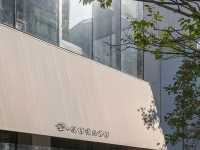 陽光明媚的戶外咖啡廳景象，白屋頂建築，巨大的窗戶，人們坐在椅子和長椅上