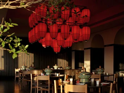 A modern dining space with a wooden floor, a dining table, and chairs, set with various bowls and cups, in a warm and welcoming atmosphere