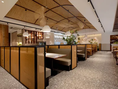 Cozy modern dining space with wooden walls, potted plants, and dim lighting