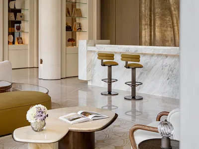 Comfortable living space with a white couch, dining table, bar area, and natural light from a large window
