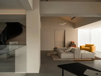 Cozy living space with a white couch, chair, and rug, surrounded by natural light and clean lines