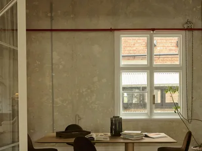 A cozy room with a wooden table and chairs, natural light from a window, and a warm atmosphere