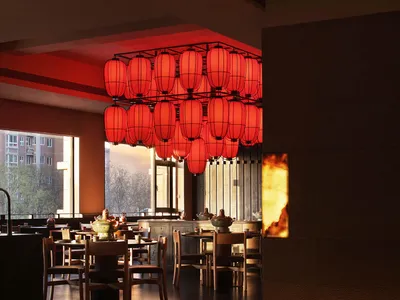 A warm and inviting restaurant dining area with a large red and white chandelier, multiple chairs and tables, and natural light from the windows