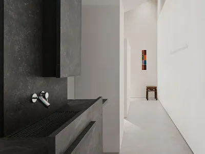 一間現代廚房內的水泥工作台、水槽和柔和的燈光創造出溫馨的氣氛