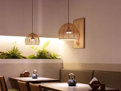 Cozy modern restaurant interior with dim lighting, artwork on the walls, and tables set with bowls and cups