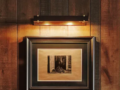 一個半暗的客廳,地板是木地板,中間放著沙發,右邊有一把椅子,創造出一個溫暖和親密的氛圍