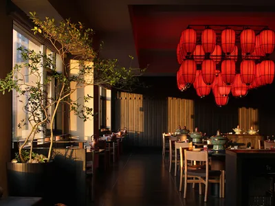 Cozy restaurant with modern design, red accents, dim lighting, and dining items