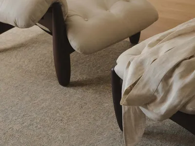 Cozy living room with a brown carpet, two chairs, and a couch, featuring dim lighting and a warm atmosphere
