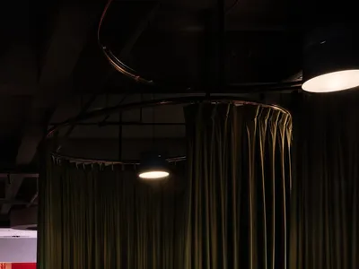 A cozy restaurant dining area with a red floor, green curtains, a dining table, and two couches, creating a welcoming atmosphere for guests