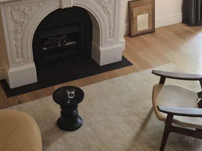 Cozy living room with a white fireplace, a chair, and inviting atmosphere