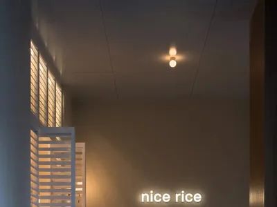 燈光明亮的餐區，靠牆擺放木製長椅，配有發光招牌，周圍有餐桌及溫馨氛圍