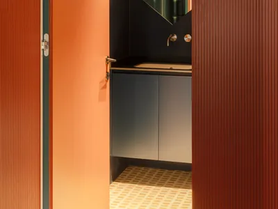 Bathroom with a blue cabinet, black countertop, and a mirror mounted above the sink, set against a dimly lit background