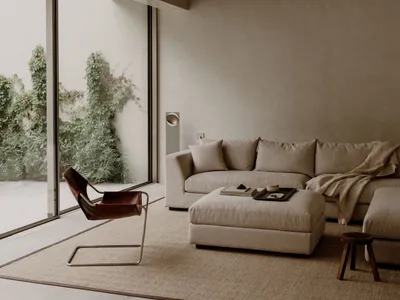 A well-lit living room with a couch, chair, and rug, featuring various decorative items and a cozy atmosphere