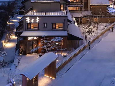 一座融合多種建築風格的大型酒店建築，坐落於寧靜雪景環繞的山野