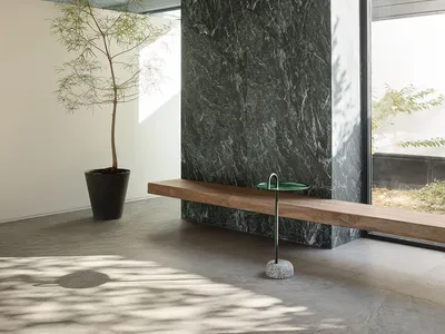Cozy living space with a wooden bench near a window and a potted plant adding a touch of greenery