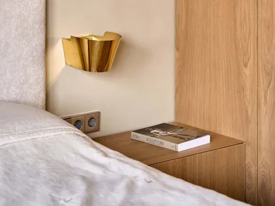 A cozy bedroom with a bed, bookshelf, and wooden wall, creating a warm and inviting atmosphere