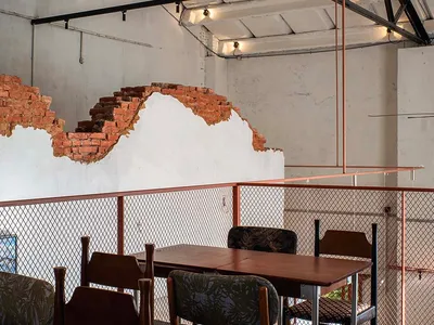 Cozy modern restaurant interior with a wooden table, brick wall, and dim lighting, encouraging social interaction and dining