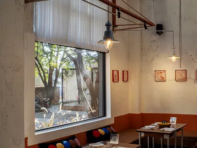明亮溫馨的餐廳內部，配有長餐桌、吧台和舒適家具，白色牆面與窗戶自然光線