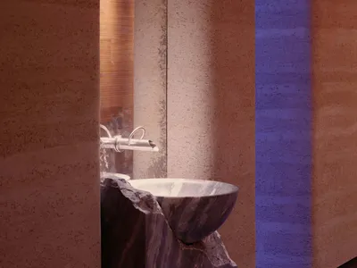 Bathroom with a sink and toilet in a dimly lit space with a stone-like appearance