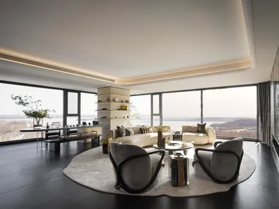 Coastal living room with a couch, chair, and dining table, surrounded by large windows with an ocean view, well-lit and inviting