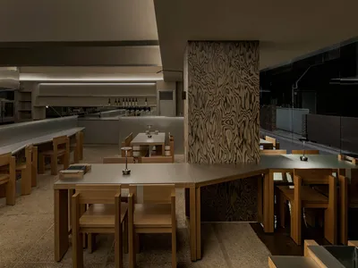 Dimly lit dining area with wooden tables and chairs, creating a cozy atmosphere