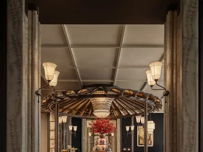 A dimly lit hotel bar with a circular design, surrounded by chairs, a dining table, and decorative items, creating a warm and inviting atmosphere