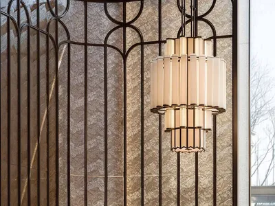 A woman stands behind a marble counter in a dimly lit hotel lobby with a chandelier and elegant atmosphere