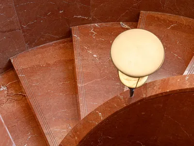 A curved marble staircase in a soft, diffused light, creating a warm and elegant atmosphere