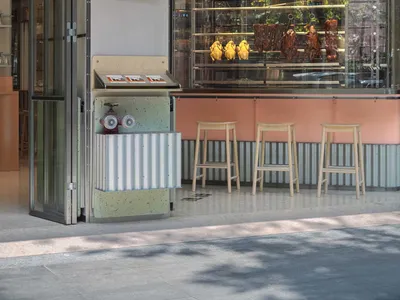 休閒餐廳，粉綠色系，設有食物展示櫃檯、座椅及背景冰箱