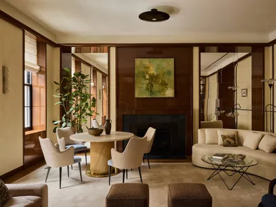 Cozy living room with a fireplace, couch, chair, dining table, and decorative items, giving a warm and inviting atmosphere