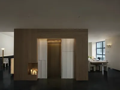 Cozy living space with a wooden door, a fireplace, and a hallway beyond