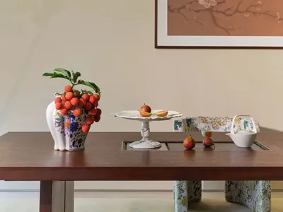 溫馨的餐廳，內有木質餐桌、一瓶水果花瓶，以及一盆盆栽，搭配柔和溫暖的燈光