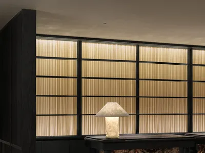 Well-lit hotel lobby with a black marble counter and a metal lamp, set against a modern backdrop