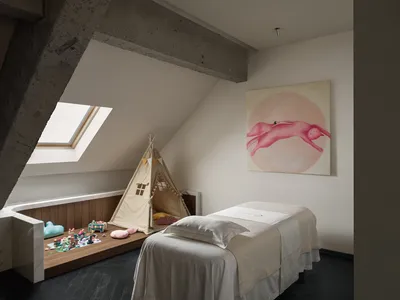 Cozy bedroom with a bed, chair, and painting, decorated with a white color scheme and small items, under a window with natural light